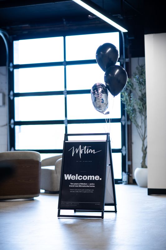 Motion welcome A-frame sign at the clinic entrance with balloons